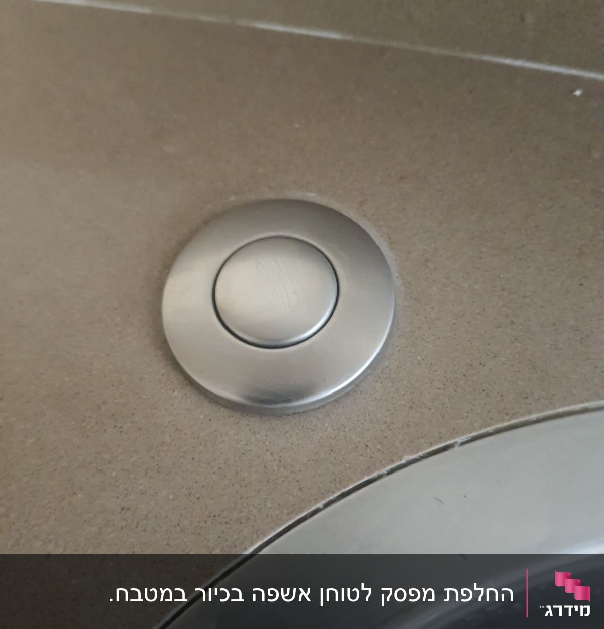כפתור מתכת עגול על משטח כיור